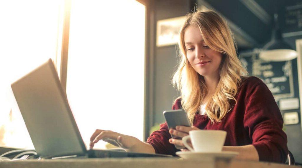 A young woman with a laptop and phone.